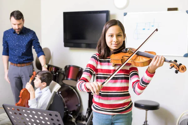 自信を持って女性学生音楽学校でヴァイオリンを演奏の基礎を学んで — ストック写真