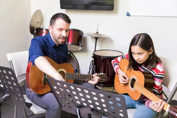 器楽曲でギター クラスのプレティーンの女の子に命令を与える音楽の先生 — ストック写真