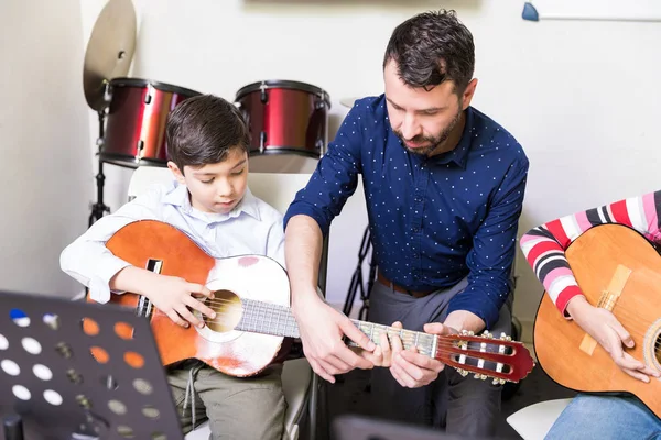 Instructor Assisting Boy Learn Fundamentals Guitar Playing Music School — Stock Photo, Image