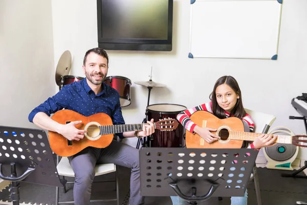 自信を持って教師と生徒が教室で座ってギターを弾いて — ストック写真