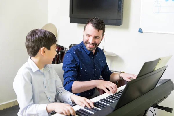音楽の授業でサウンド シンセサイザーを演奏の講師トレーニング少年の笑顔 — ストック写真