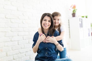 Sevimli küçük kız güzel anne arkadan evde duvara yakın sarılma