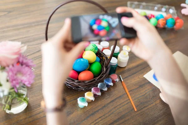 Cropped image of woman capturing pictures of Easter basket and posting it online