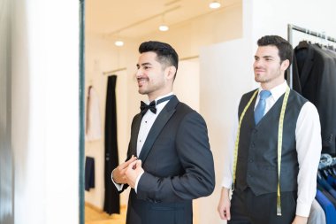 Mutlu müşteri kendisi ile satıcı dükkanda duran hayran takım elbiseli