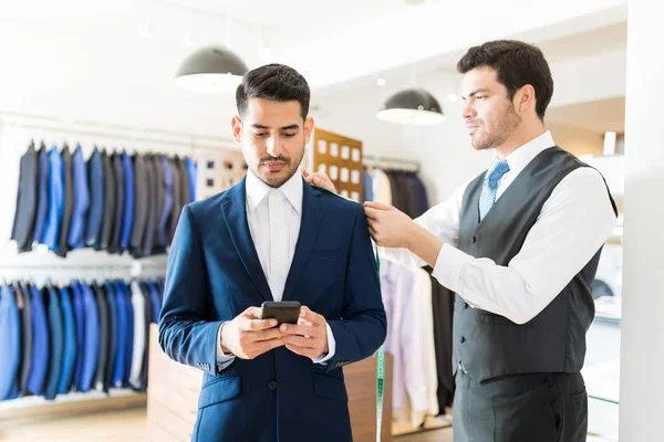 Eleganter Junger Mann Mit Smartphone Während Seinem Professionellen Schneider Geschäft — Stockfoto