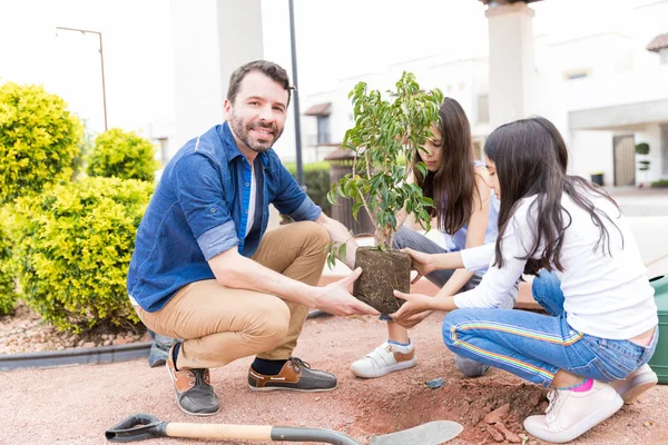 Bello Padre Sorridente Mentre Aiuta Figlia Piantare Piccolo Albero Giardino — Foto Stock