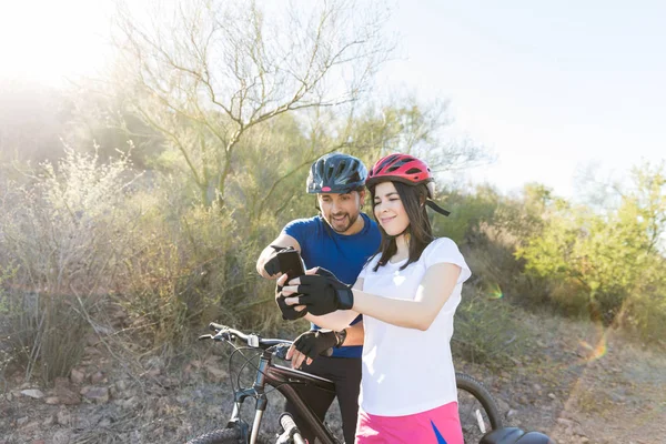 Rowerzyści Przy Użyciu Smartfona Nawigacji Podczas Jazdy Rowerem Górskim Szlaku — Zdjęcie stockowe