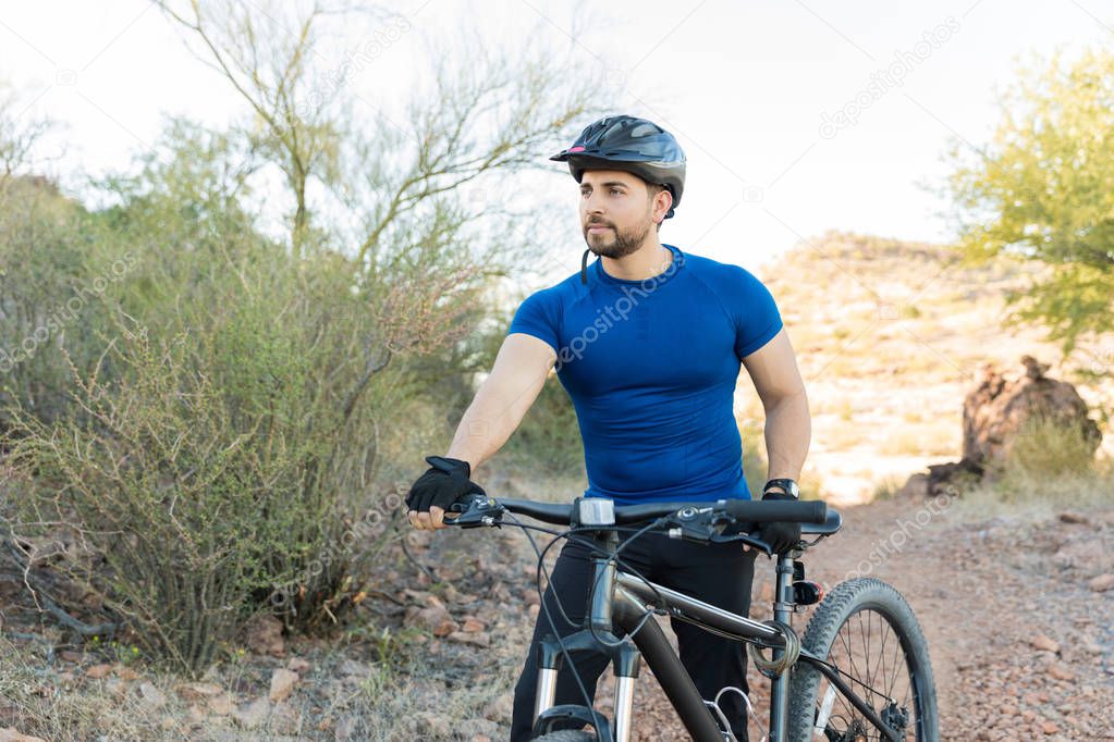 Young man walking with bicycle and improving self endurance by routine exercise