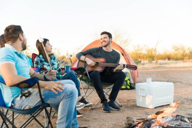Şenlik ateşi yakın arkadaşlarıyla otururken gitar koparma halinden memnun