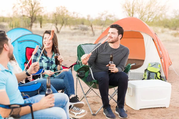 Joven Latino Con Amigos Disfrutando Salchichas Cerveza Mientras Acampa Bosque —  Fotos de Stock