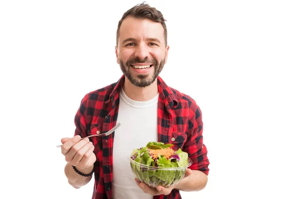 白い背景に対してサラダを食べながら微笑む健康な男の肖像 — ストック写真