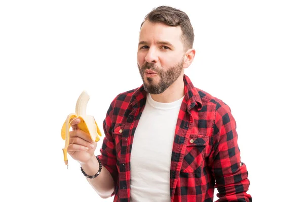 普通の背景に対してより良い消化のためにバナナを持つ幸せな髭の男 — ストック写真