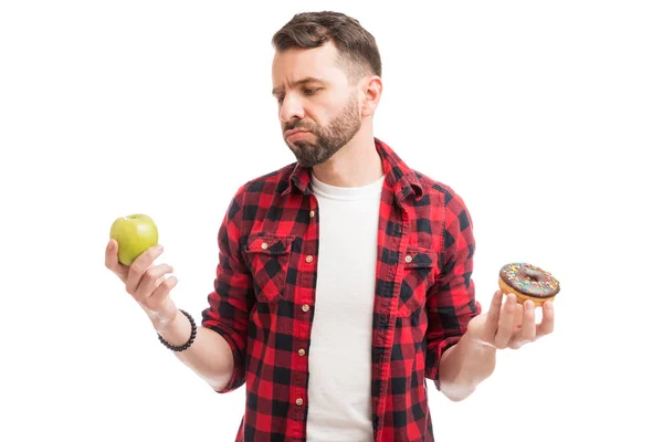 Förvirrad Mitten Vuxen Man Väljer Mellan Choklad Munk Och Äpple — Stockfoto