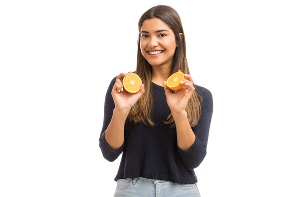 快乐的女人添加更多的维生素在她的饮食通过橙色水果在工作室 — 图库照片