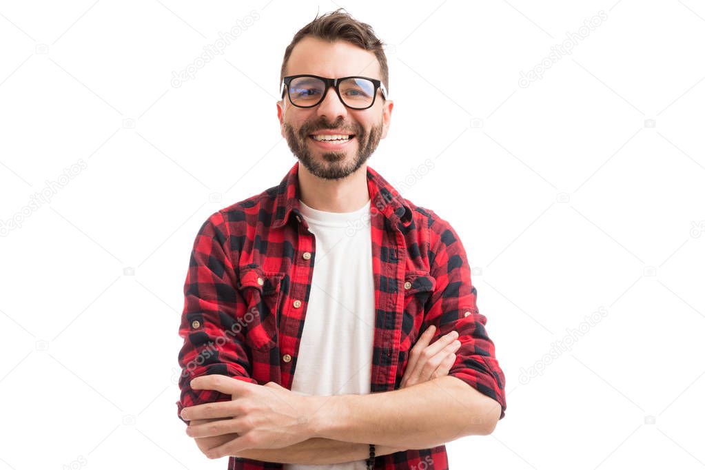 Smiling nerdy man wearing eyeglasses while crossing arms on white