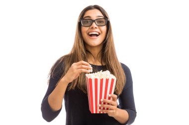 Beyaz arka planda 3D film izlerken patlamış mısır sahip heyecanlı kadın