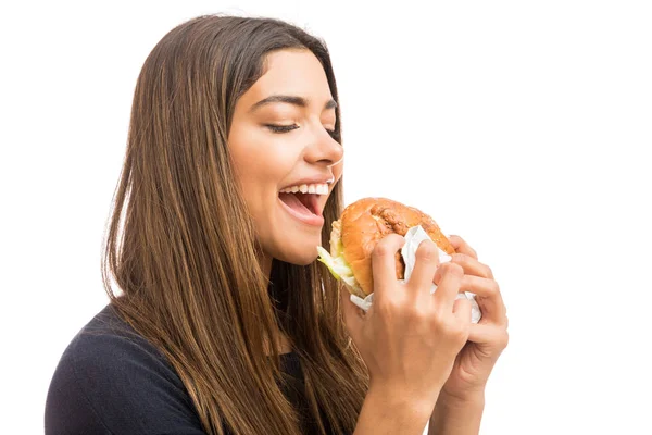 华丽拉丁妇女与棕色头发吃大汉堡在白色背景 — 图库照片