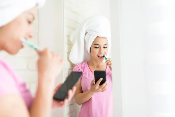 Mujer Limpiando Dientes Con Cepillo Utilizando Internet Teléfono Inteligente Baño — Foto de Stock