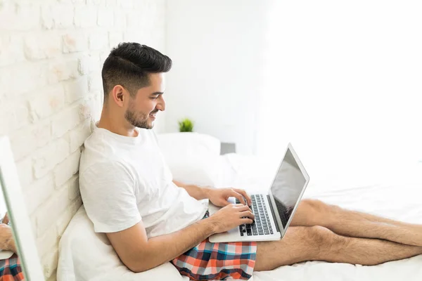 Jovem Sorridente Usando Laptop Durante Seu Tempo Lazer Casa — Fotografia de Stock