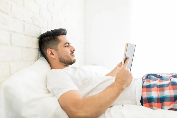 Side View Handsome Man Reading Book While Lying Bed — Stock Photo, Image