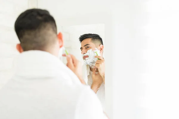 在家庭浴室用剃须刀英俊的人剃须脸 — 图库照片