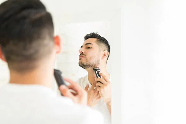 Schöner Lateinischer Mann Trockenrasur Gesichtsbehaarung Mit Elektrischem Trimmer Badezimmer — Stockfoto