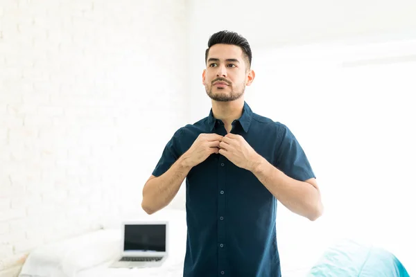 Jovem Bonito Abotoando Sua Camisa Quarto Brilhantemente Iluminado — Fotografia de Stock