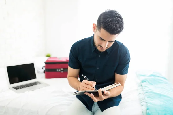 Knappe Jonge Man Schriftelijk Agenda Zittend Bed — Stockfoto