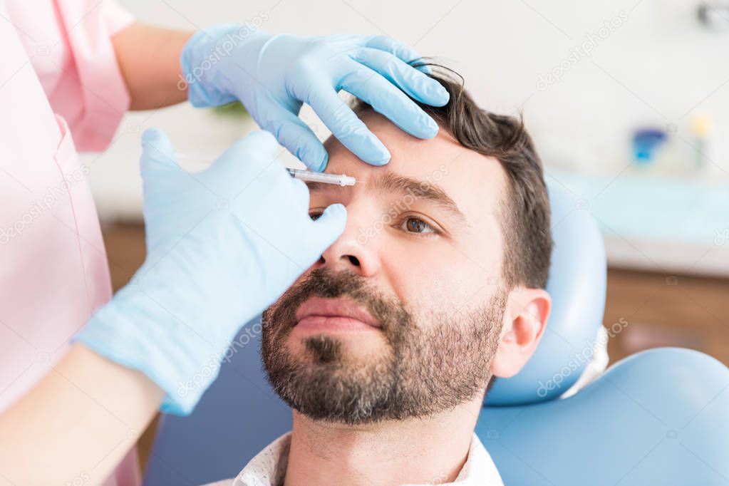 Mid adult man going through cosmetic treatment to keep looking young and healthy