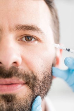 Cilt bakım kliniğinde Botoks tedavisi gören adamın kırpılmış görüntüsü