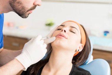 Kırpılmış erkek doktor geçici olarak dudaklara anlık hacim ve kontur ekler dolgu enjekte