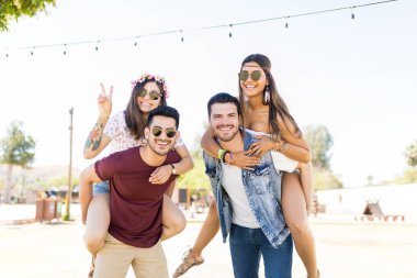 Latin erkekler müzik festivalinde güzel kadınlara piggyback binmek veren