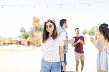 Büyüleyici Latin kadın güneşli bir günde müzik festivali kutlarken gülümseyen