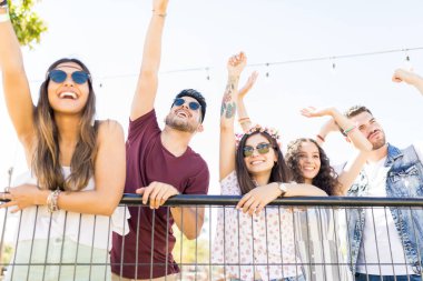 Müzik festivalinde zevk korkuluk tarafından neşeli erkek ve kadın hayranları