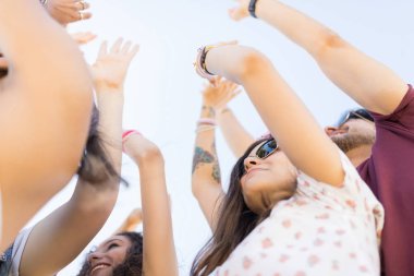 Müzik festivalinde birlikte dans eden genç arkadaşların düşük açılı görünümü