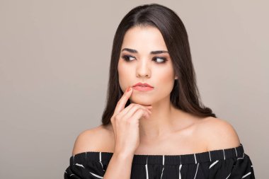 Izole arka plan karşı uzağa bakarak omuzlarını giyen düşünceli kadın