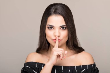 Çekici orta yetişkin kadın renkli arka plan üzerinde sessizlik jest yapıyor
