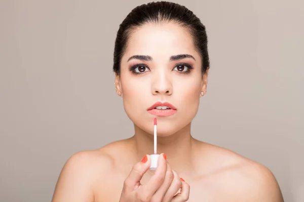 Mooie Brunette Zetten Sommige Lippenstift Tegen Beige Achtergrond — Stockfoto