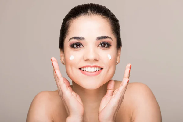 Hermosa Morena Sonriente Con Crema Cara Gestos Sobre Fondo Beige — Foto de Stock