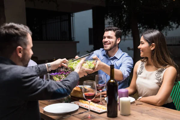 夜に家の外で友人と食べ物を持っている陽気な男 — ストック写真