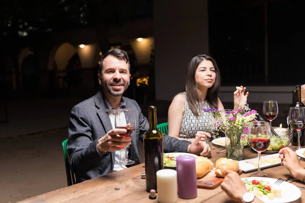 Retrato Homem Sorridente Tomando Vinho Enquanto Desfruta Jantar Com Amigos — Fotografia de Stock