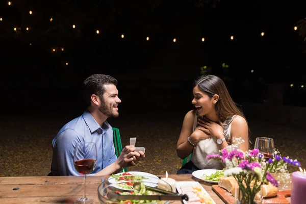 惊讶的女人看着男友在餐厅举行的订婚戒指 — 图库照片