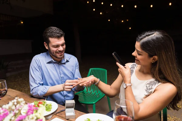 在后院的宴会上 女人给男朋友拍照 把戒指戴在手指上放在餐桌前 — 图库照片