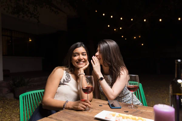 Mujer Susurrando Secretos Oído Mejor Amigo Mientras Toma Vino Mesa —  Fotos de Stock
