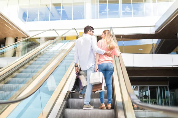 Alışveriş Merkezinde Yürüyen Merdivenüzerinde Alışveriş Poşetleri Taşıyan Casuals Sevenlerin Arka — Stok fotoğraf