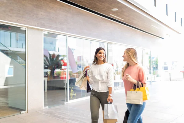 Trendy genç bayan arkadaşlar alışveriş merkezinde hafta sonu zevk
