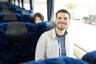 Otobüste oturan gülümseyen yakışıklı gezgin
