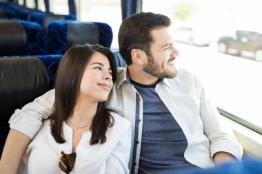Otobüste seyahat ederken pencereden bakan gülümseyen çift