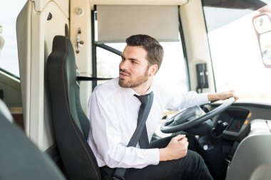 Yakışıklı genç otobüs şoförü tur gezisi başlamadan önce arkasına bakıyor