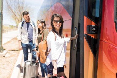 Turist otobüsüne girmek üzere olan sırt çantası yla iyi görünümlü orta yetişkin kadın 